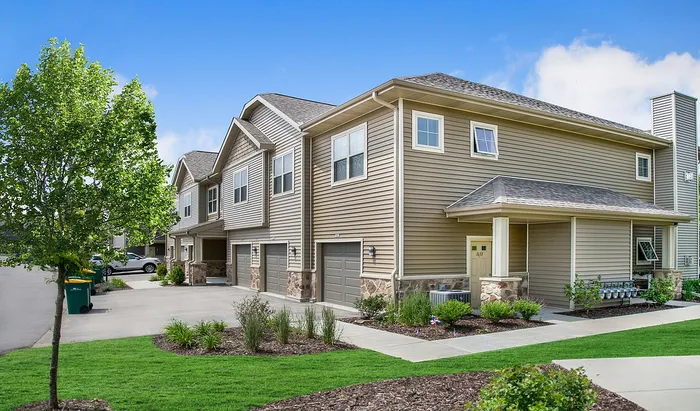 Exterior view of High Bluff Townhomes in Grafton, Wisconsin showcasing the apartment buildings and community layout.