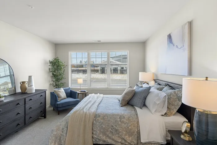 Primary bedroom at Seasons at Grafton Apartments in Grafton, Wisconsin offering generous space and flexible furniture layouts.