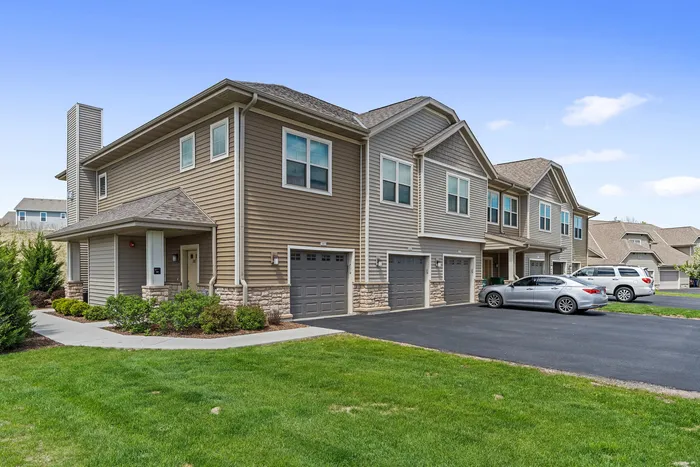 Exterior view of High Bluff Townhomes in Grafton, Wisconsin showcasing the apartment buildings and community layout.