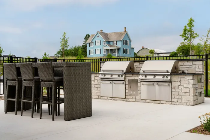 Outdoor grilling stations at Seasons at Grafton Apartments in Grafton, Wisconsin designed for casual outdoor dining.