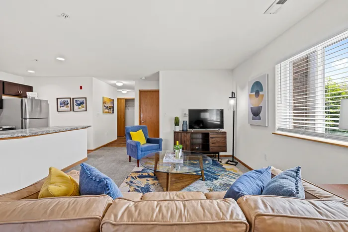 Living room at Saddlebrook Apartments in Pewaukee, Wisconsin with open layout and natural light.