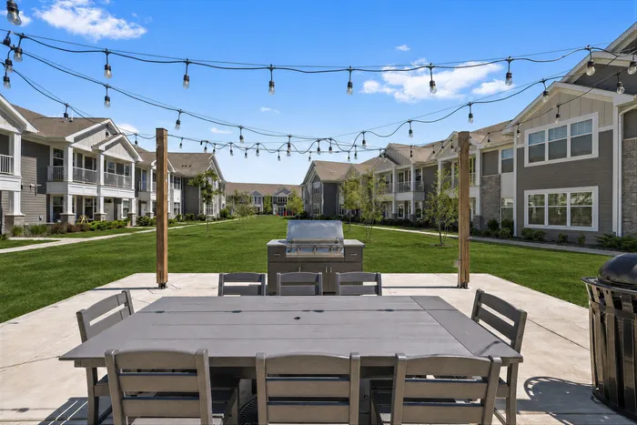 Outdoor resident seating area and grilling station at Seasons at River View Apartments in Pleasant Prairie, Wisconsin.