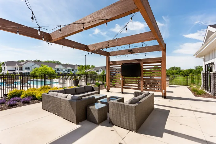Outdoor pergola lounge with seating and TV at Seasons at Franklin apartments in Franklin, Wisconsin.