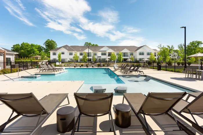 Luxury apartment pool with tanning ledge and in-water lounger chairs at Seasons at Franklin in Franklin, Wisconsin.