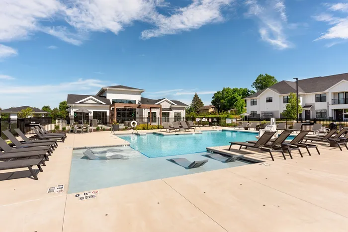 Resort-style outdoor pool with sundeck and lounge chairs at Seasons at Franklin apartments in Franklin, Wisconsin.