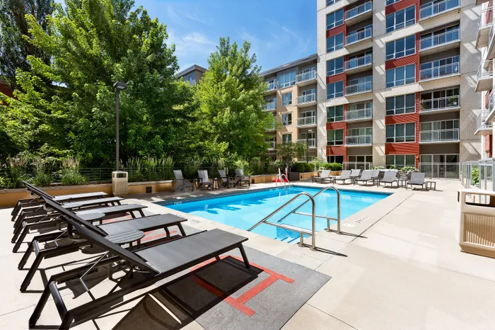 Resort-style swimming pool with lounge chairs at Domain Apartments in Downtown Madison, Wisconsin.