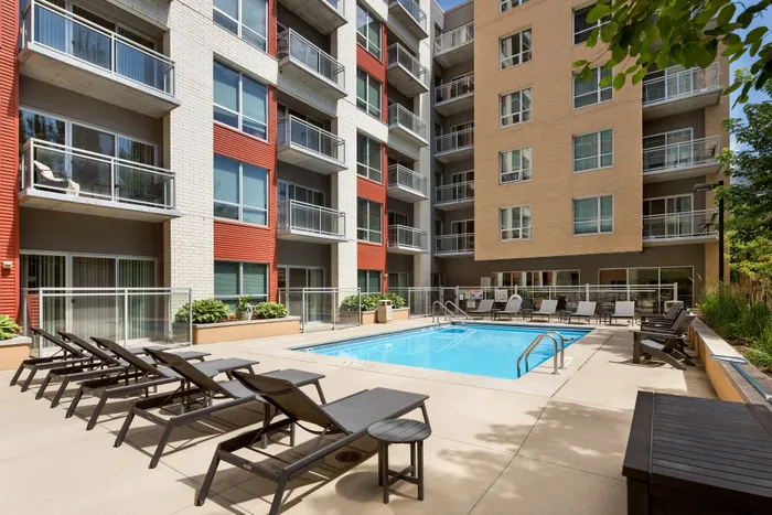 Resort-style swimming pool with lounge chairs at Domain Apartments in Downtown Madison, Wisconsin.