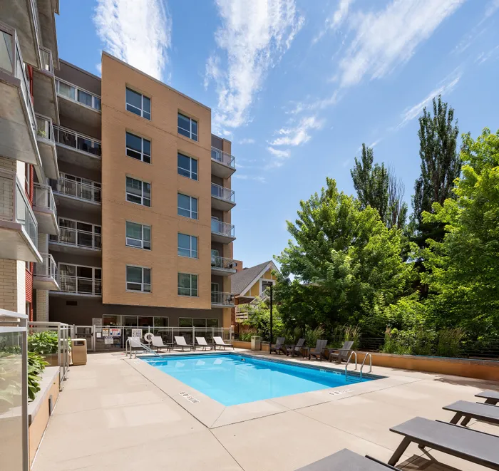 Resort-style swimming pool with lounge chairs at Domain Apartments in Downtown Madison, Wisconsin.