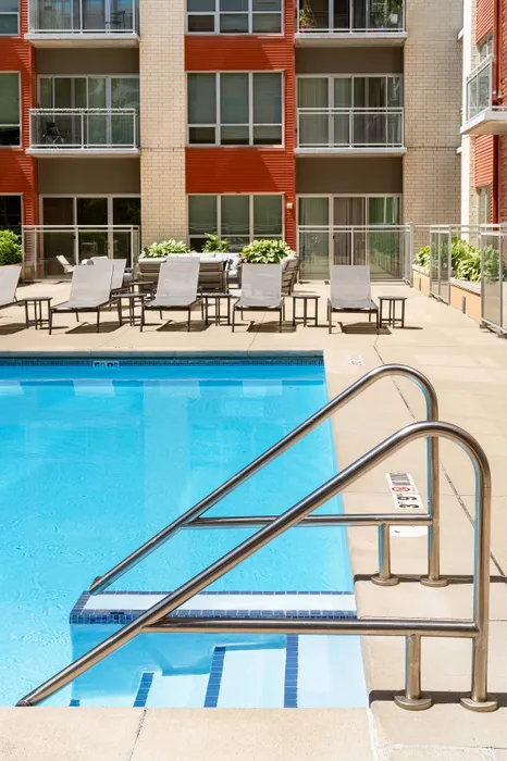 Resort-style swimming pool with lounge chairs at Domain Apartments in Downtown Madison, Wisconsin.