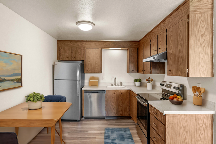 Inviting kitchen featuring wood cabinetry, modern appliances, and a cozy dining area.