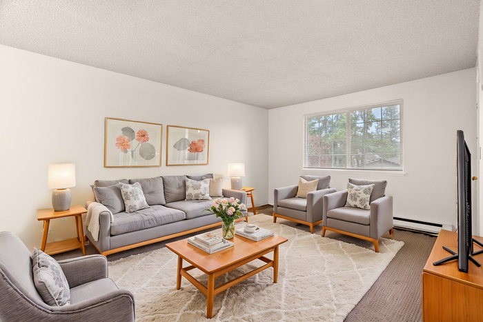 Chic living room featuring cozy gray seating, stylish wooden furniture, and floral artwork.