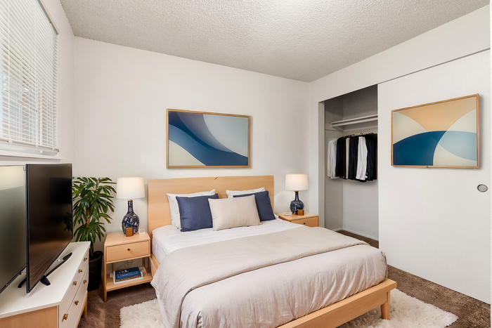 Inviting bedroom with modern decor, featuring a comfortable bed, stylish artwork, and elegant lighting.