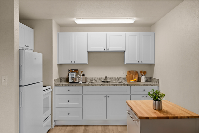 Modern kitchen with sleek white cabinetry, granite countertops, and an inviting kitchen island.