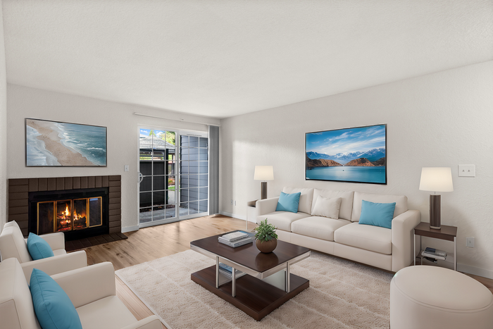 Bright and modern living room with a cozy fireplace, large sliding glass doors, and stylish furniture.