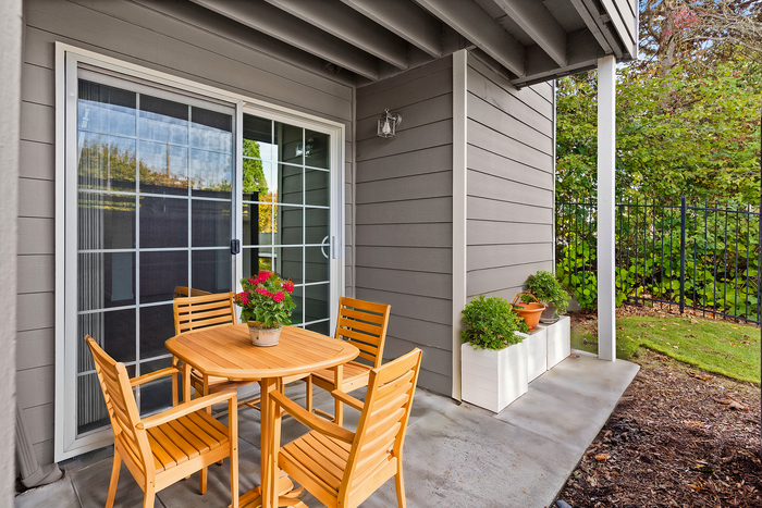 Inviting outdoor patio with wooden furniture and vibrant plants.