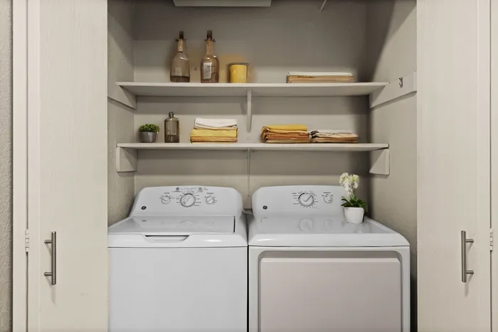 Modern laundry area featuring a sleek washer and dryer with organized shelving.