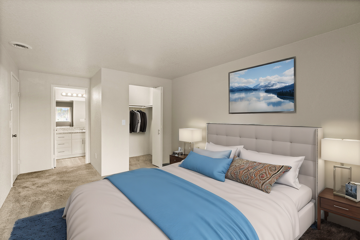 Elegant bedroom featuring a plush bed with blue accents, a walk-in closet, and an adjoining en-suite bathroom.