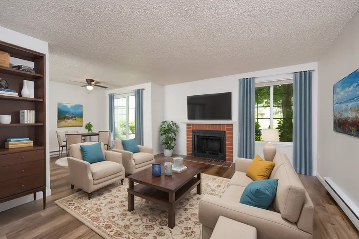 Inviting living room with beige sofas, blue cushions, a fireplace, and large windows with blue curtains.
