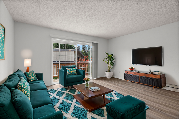 Bright and stylish living room with vibrant teal furniture, large window, and modern decor.