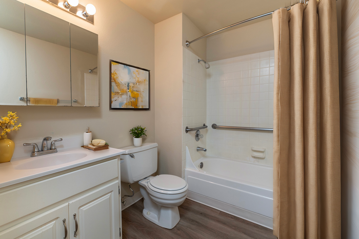 Chic bathroom with modern fixtures, white vanity, stylish artwork, and a soothing shower area.