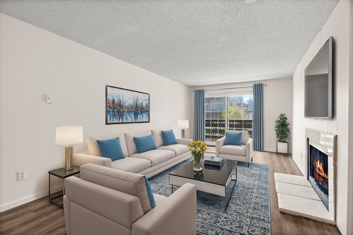 Bright and inviting living room with large windows, stylish furniture, and a cozy fireplace.