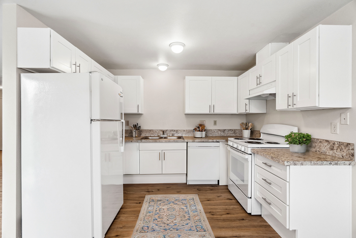 Bright and airy kitchen featuring sleek white cabinets, marble countertops, and modern appliances.