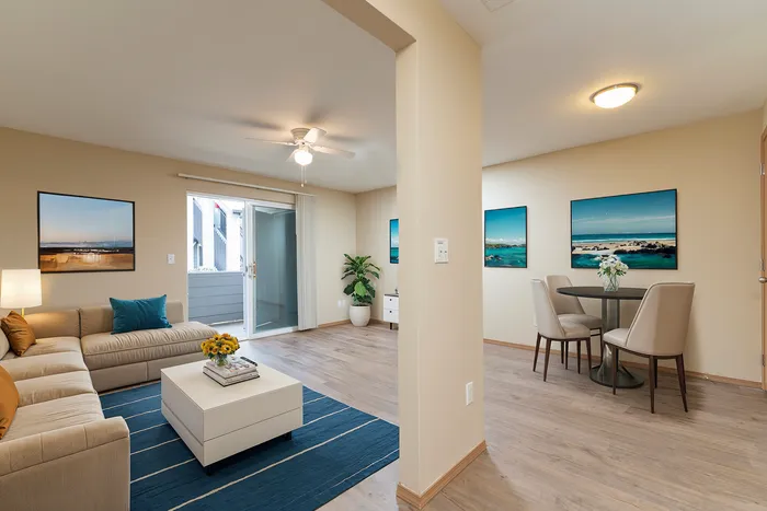 Bright modern living room with a cozy sectional sofa, a stylish coffee table, and a dining nook with elegant seating.