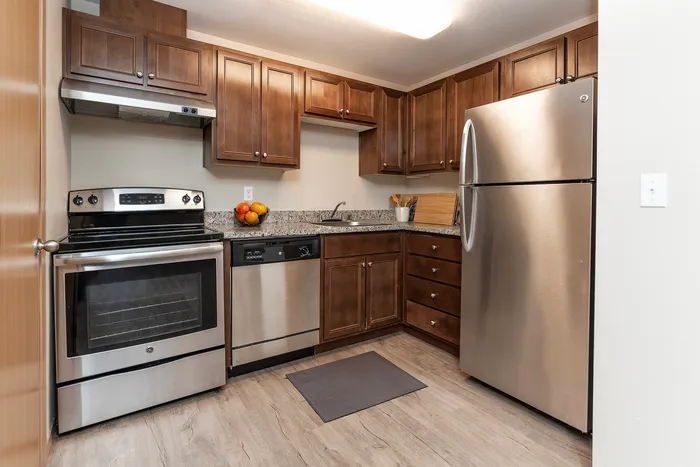 Sleek kitchen with stainless steel appliances, wooden cabinetry, and granite countertops.