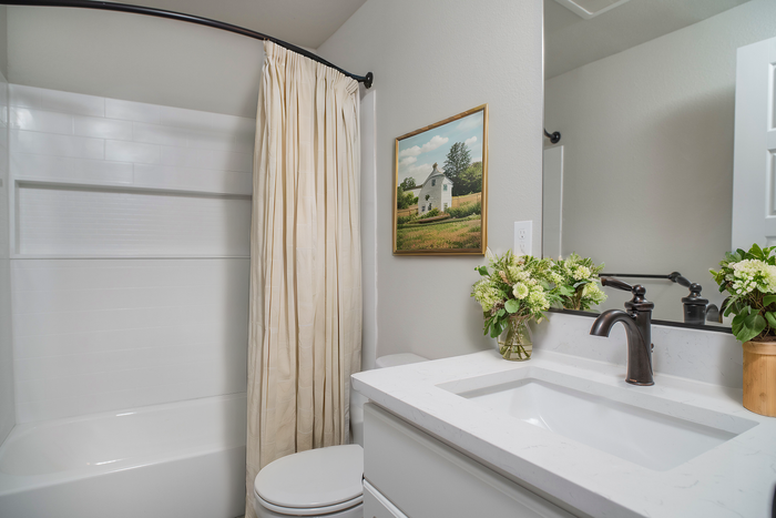 Chic bathroom with a white vanity, elegant fixtures, and soothing decor accents.