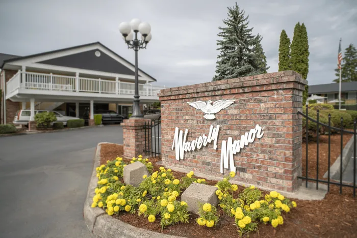 Charming entrance to Waverly Manor with elegant brick signage and lush landscaping.