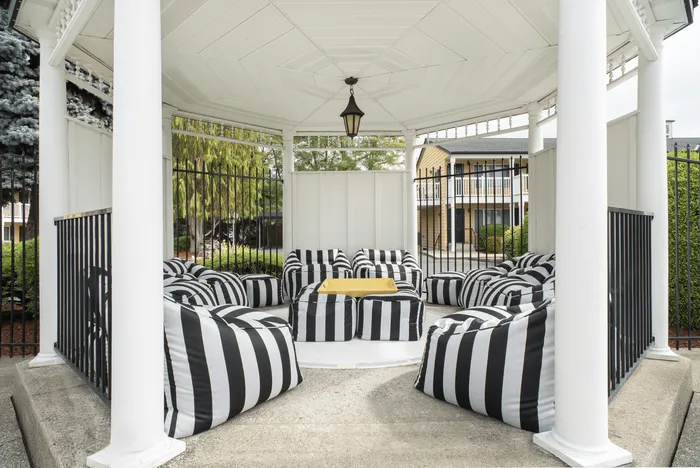 Stylish outdoor seating area with black and white striped bean bags under a gazebo.