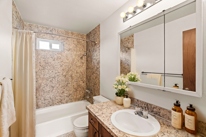 Beautifully designed bathroom featuring a granite countertop, modern lighting, and relaxing d&eacute;cor.