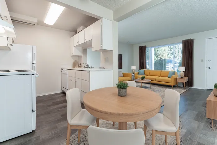 Bright and airy open-concept living space with modern kitchen, cozy dining area, and vibrant yellow sofa in a sunlit living room.