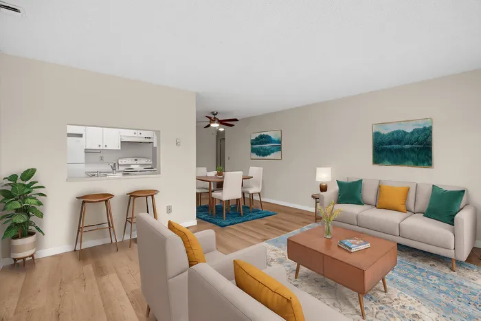 Elegant open-concept living room with modern furnishings, cozy dining area, and a sleek pass-through kitchen design.