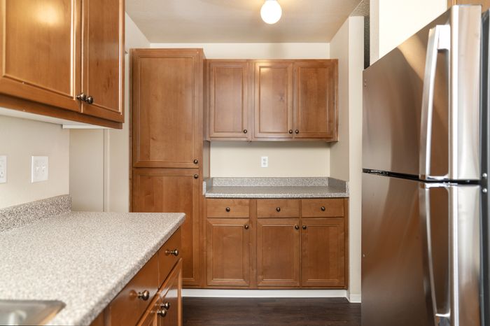 Charming kitchen with rich wooden cabinetry, sleek countertops, and a modern stainless steel refrigerator.