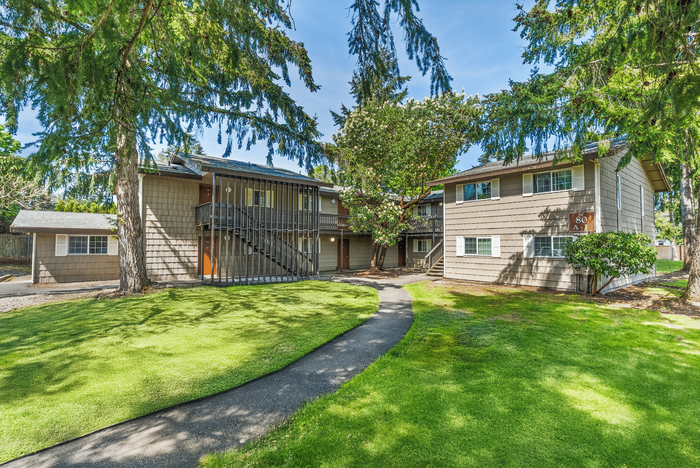 Picturesque view of a two-story apartment building surrounded by lush greenery.