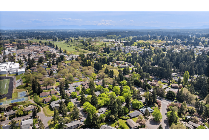 Aerial view of the community and surrounding area with a beautiful view of Mount Rainier in the background.
