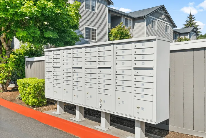 Outdoor mailbox area nestled in a beautifully landscaped apartment complex, offering a secure and convenient mail solution for residents.