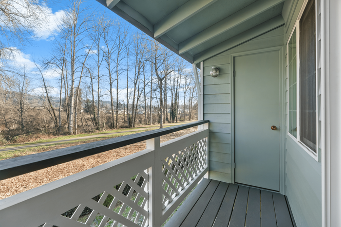 Charming balcony view featuring serene woods and clear blue skies, perfect for relaxing and enjoying nature.