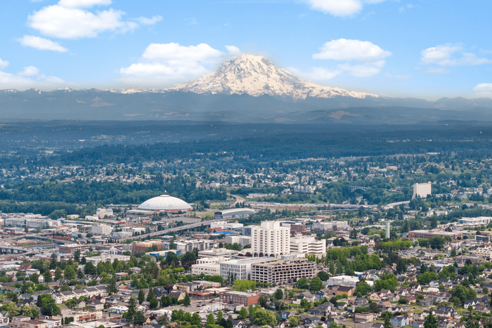Breathtaking cityscape of a vibrant urban area with a stunning mountain backdrop, offering a perfect blend of nature and urban living.