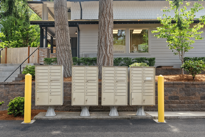 Charming and secure apartment mailboxes surrounded by lush greenery and modern architecture.