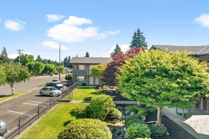 Charming suburban apartment with lush landscaping and convenient parking in a tranquil neighborhood setting.