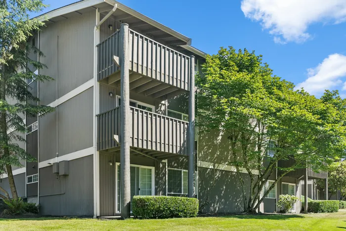 Charming apartment complex with private balconies and lush green surroundings, perfect for serene living.