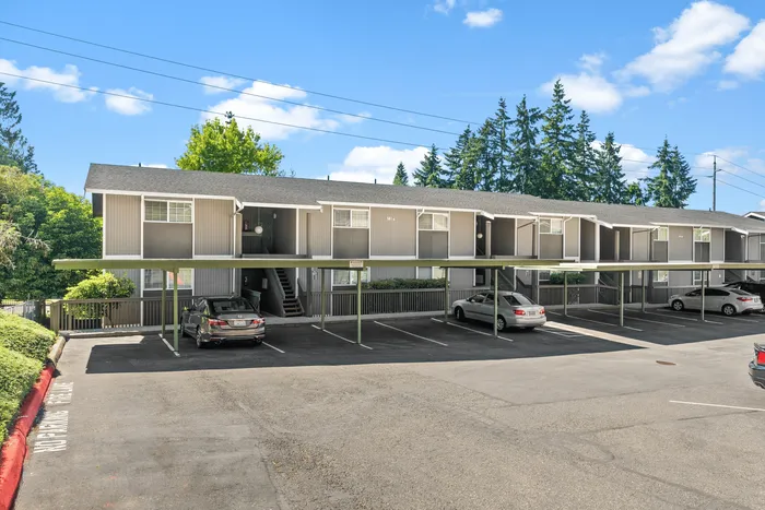 Charming apartment complex with covered parking nestled in a green, serene neighborhood.