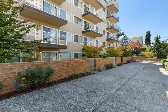 Modern apartment building with stylish balconies and lush landscaping, offering luxurious urban living.