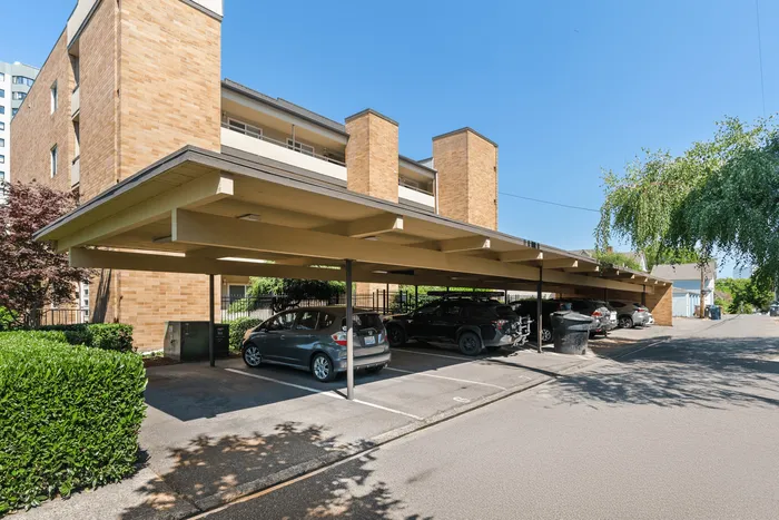 Exceptional apartment complex showcasing covered parking with clean, modern design and lush greenery in a serene environment.