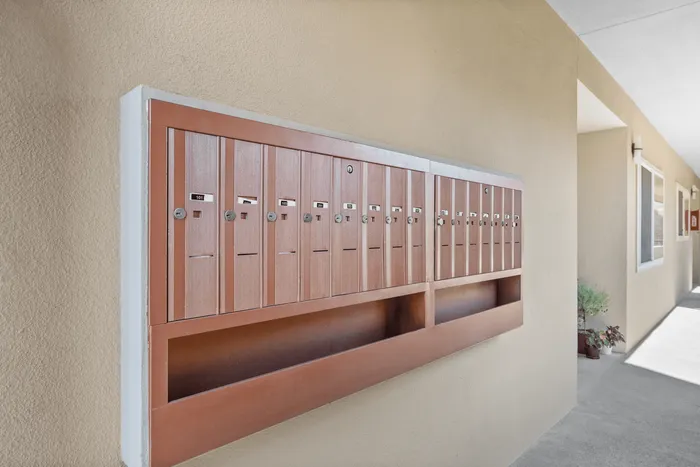 Modern apartment corridor with secure, rustic wood-finish mailboxes, inviting a sense of community and convenience.