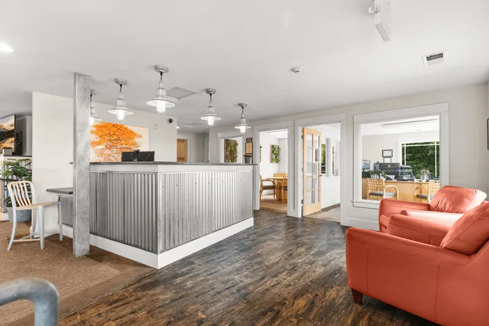 Welcoming modern office space with a stylish front desk, vibrant artwork, and cozy seating area.