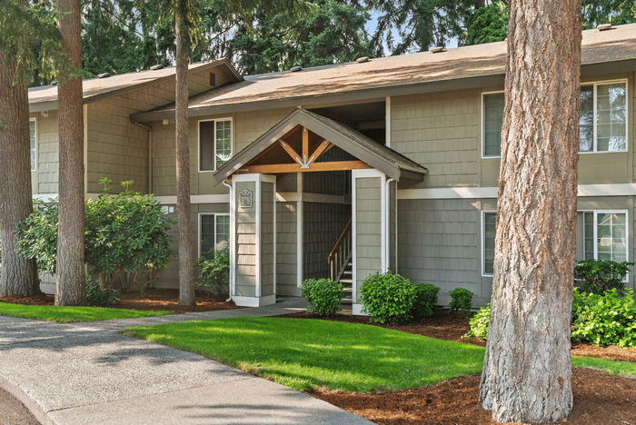Charming apartment entrance surrounded by lush greenery, showcasing tranquility and modern living.