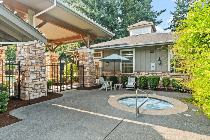Charming outdoor space featuring a cozy hot tub, stylish lounge chairs, and a serene garden backdrop for ultimate relaxation.
